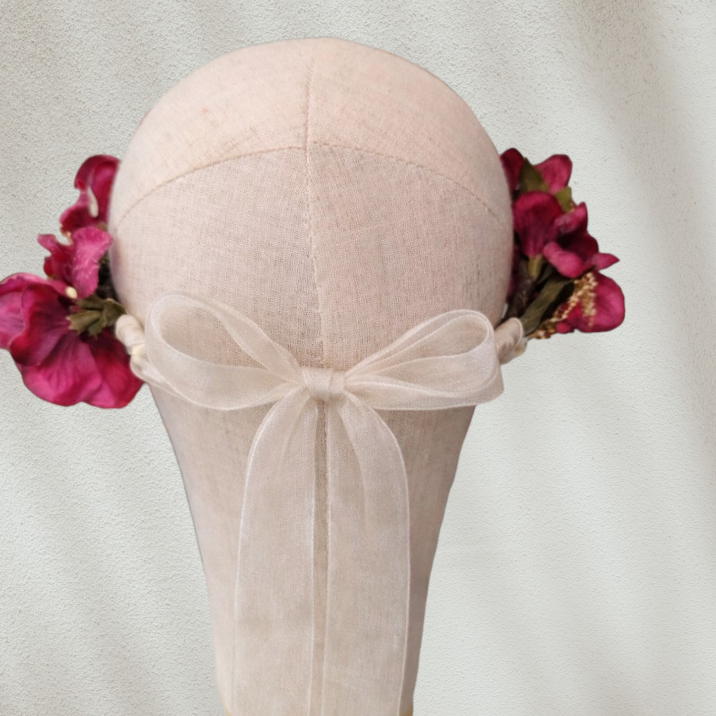 Corona floral artesanal en color burdeos para novia o invitada, con flores de estilo natural.