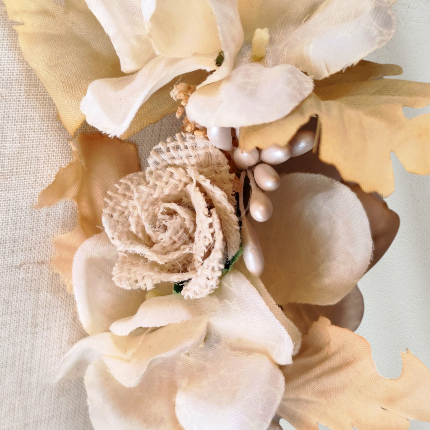 Tocado floral artesanal en tonos blanco roto para novia.