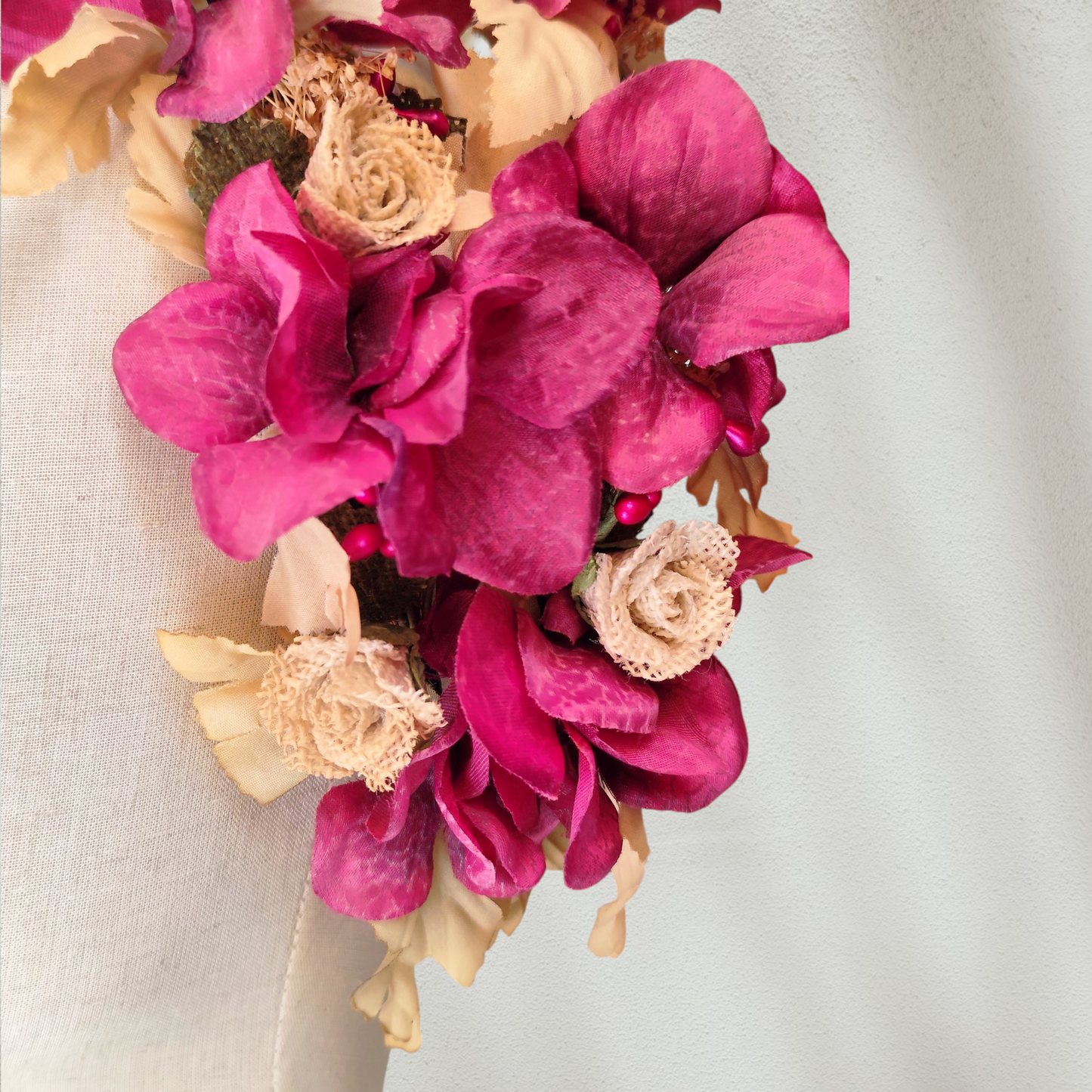 Tocado floral artesanal en tonos burdeos para novia o invitada.