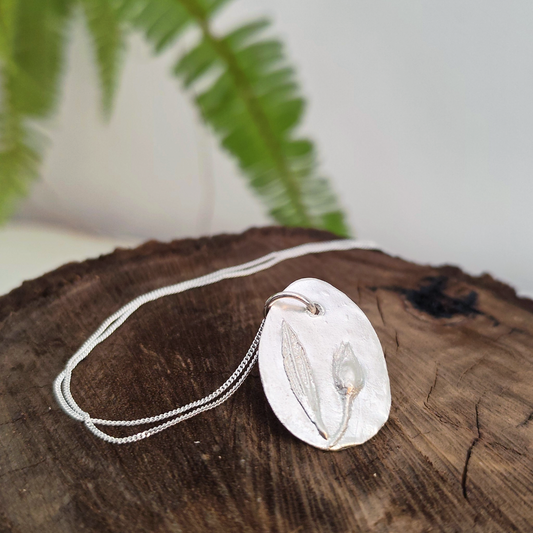 Medalla de plata con capullo y hoja de jara en relieve y cadena fina