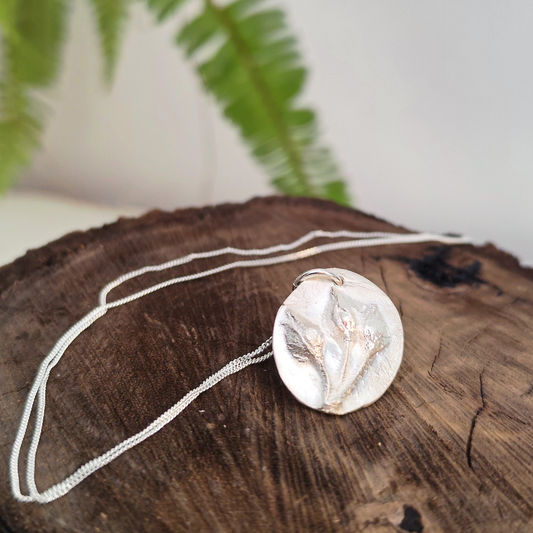 Medalla de plata con tres capullos de jara en relieve y cadena fina