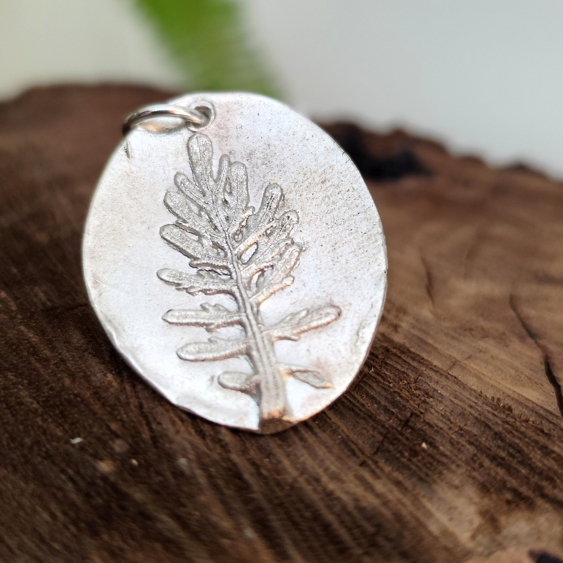 Detalle del relieve de hoja de coronas de reina en medalla de plata artesanal