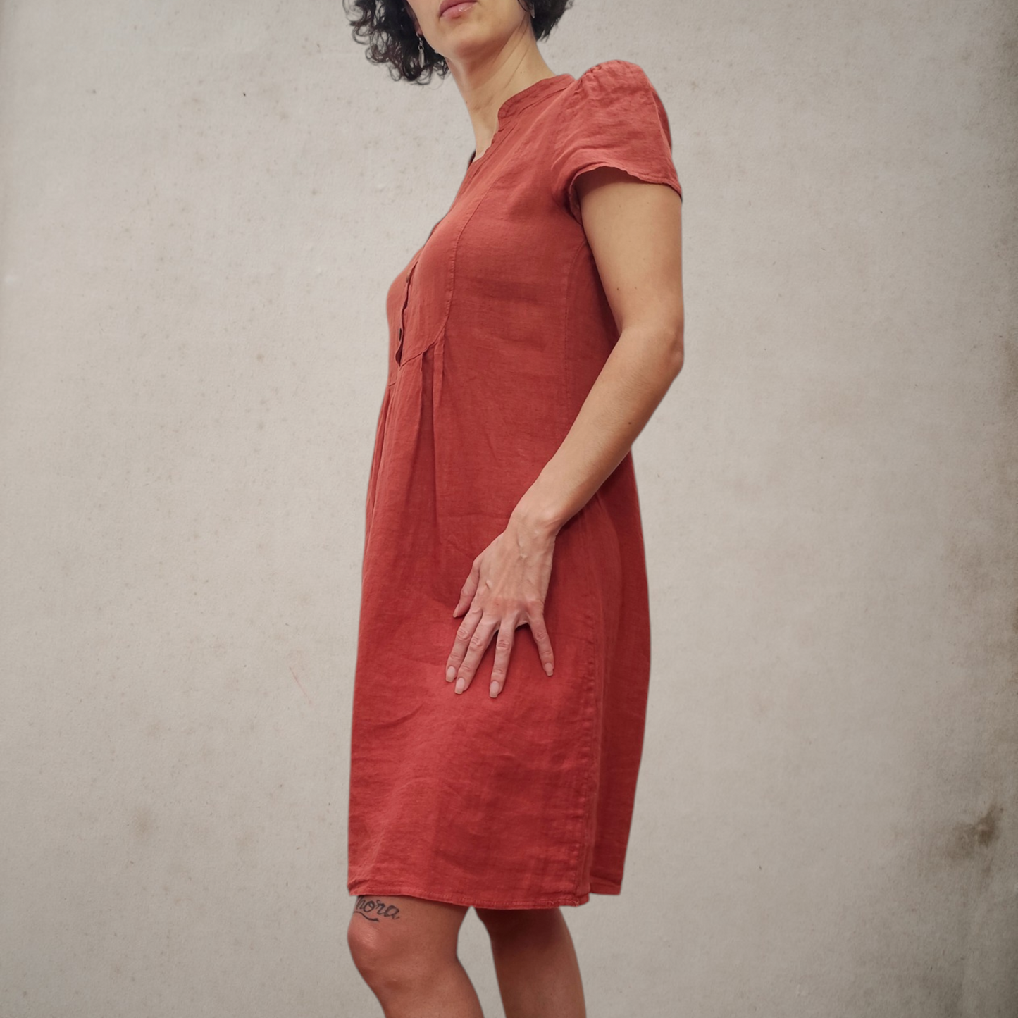 Vista lateral de vestido de lino color terracota con corte cómodo y silueta estilizada