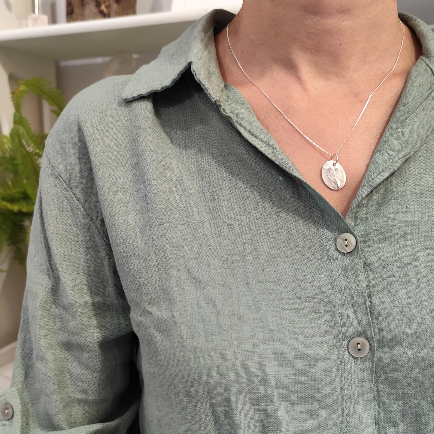 Mujer con colgante de plata con huella de hoja de haya romana en relieve y cadena fina