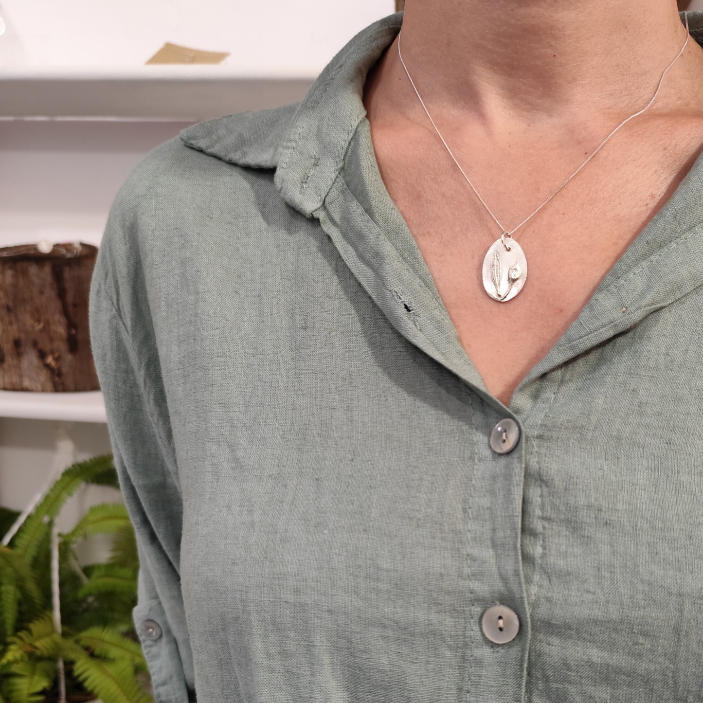 Mujer con colgante de plata con capullo y hoja de jara en relieve y cadena fina