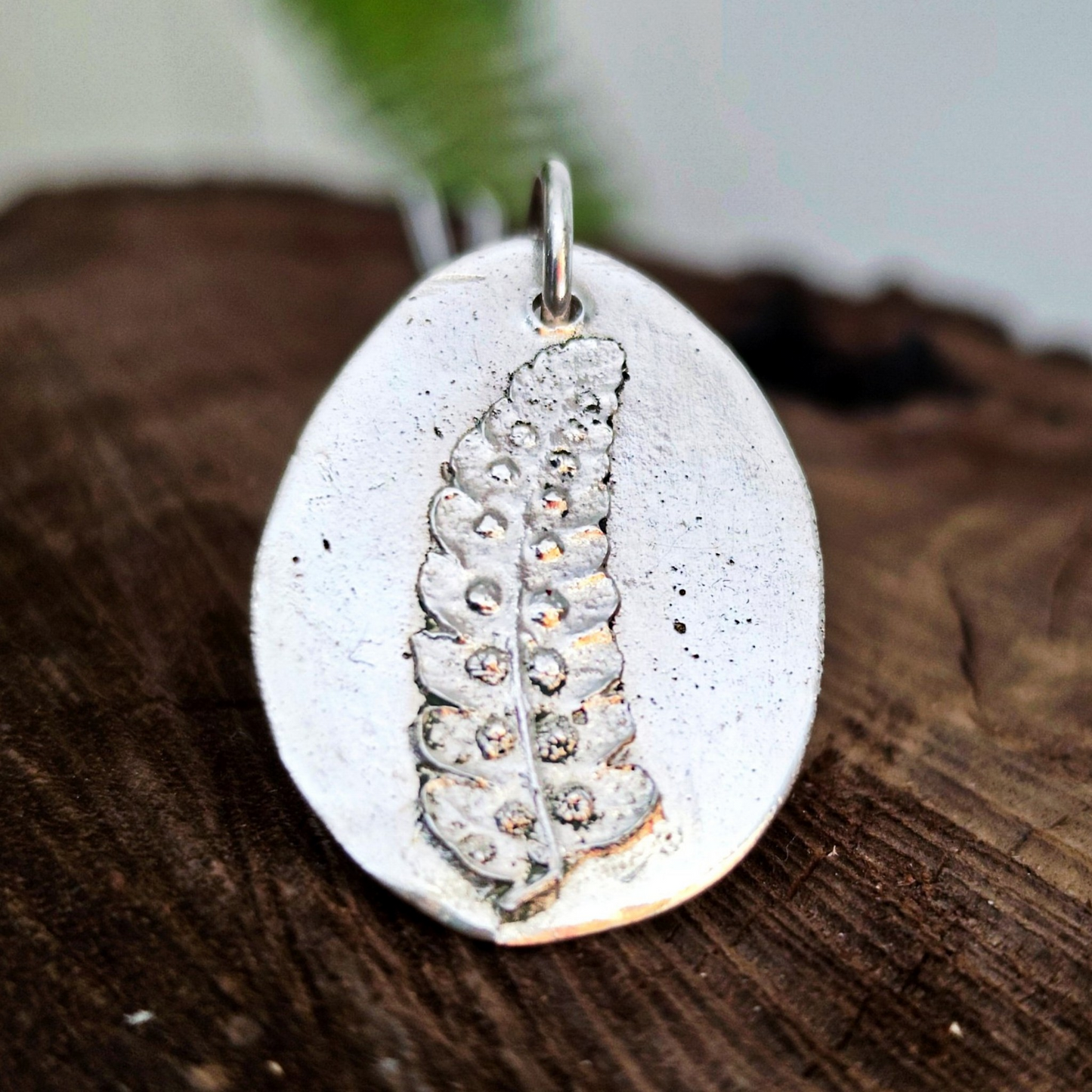 Detalle del relieve de helecho en colgante de plata artesanal