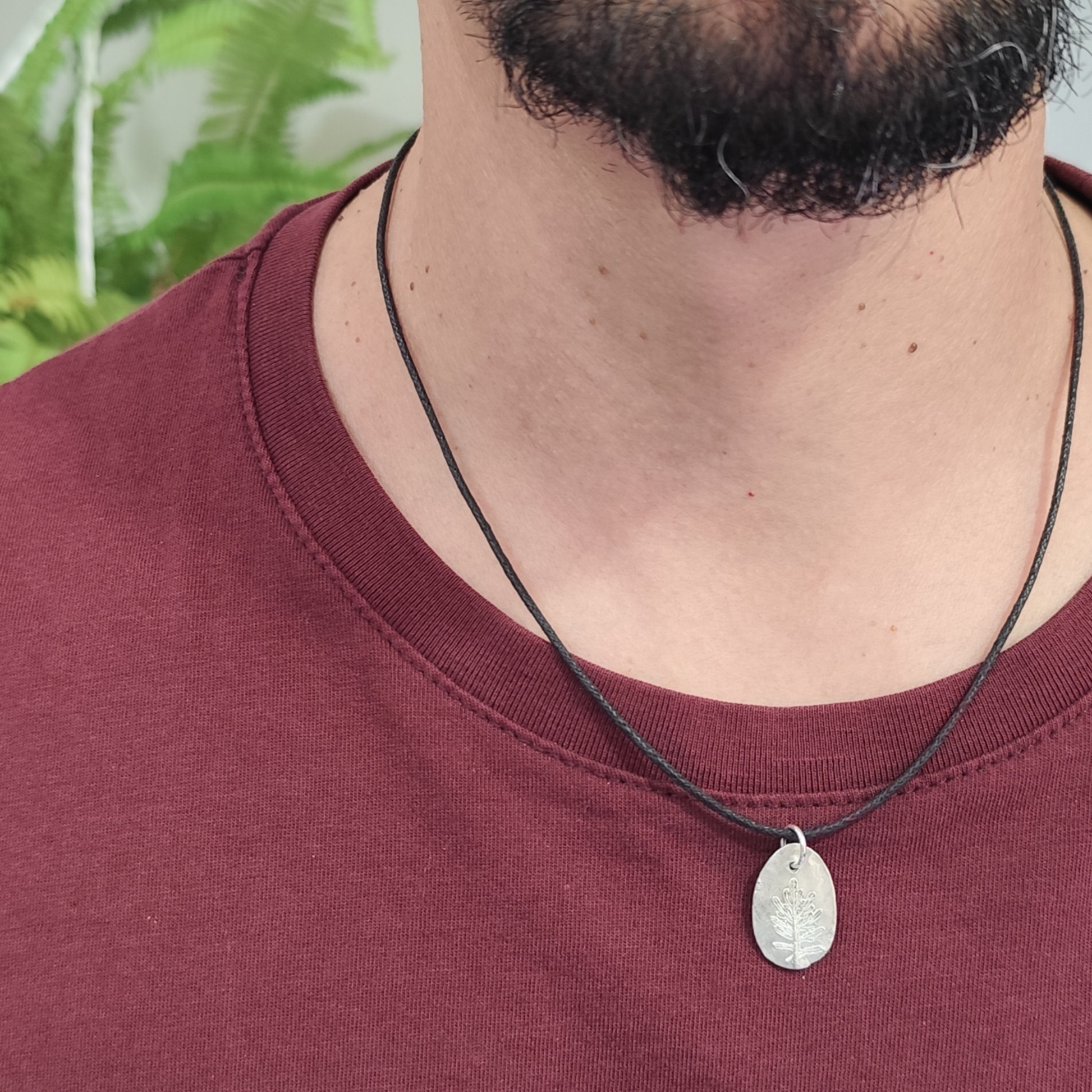Medalla botánica de plata con hoja de coronas de reina llevada por hombre con cordón negro