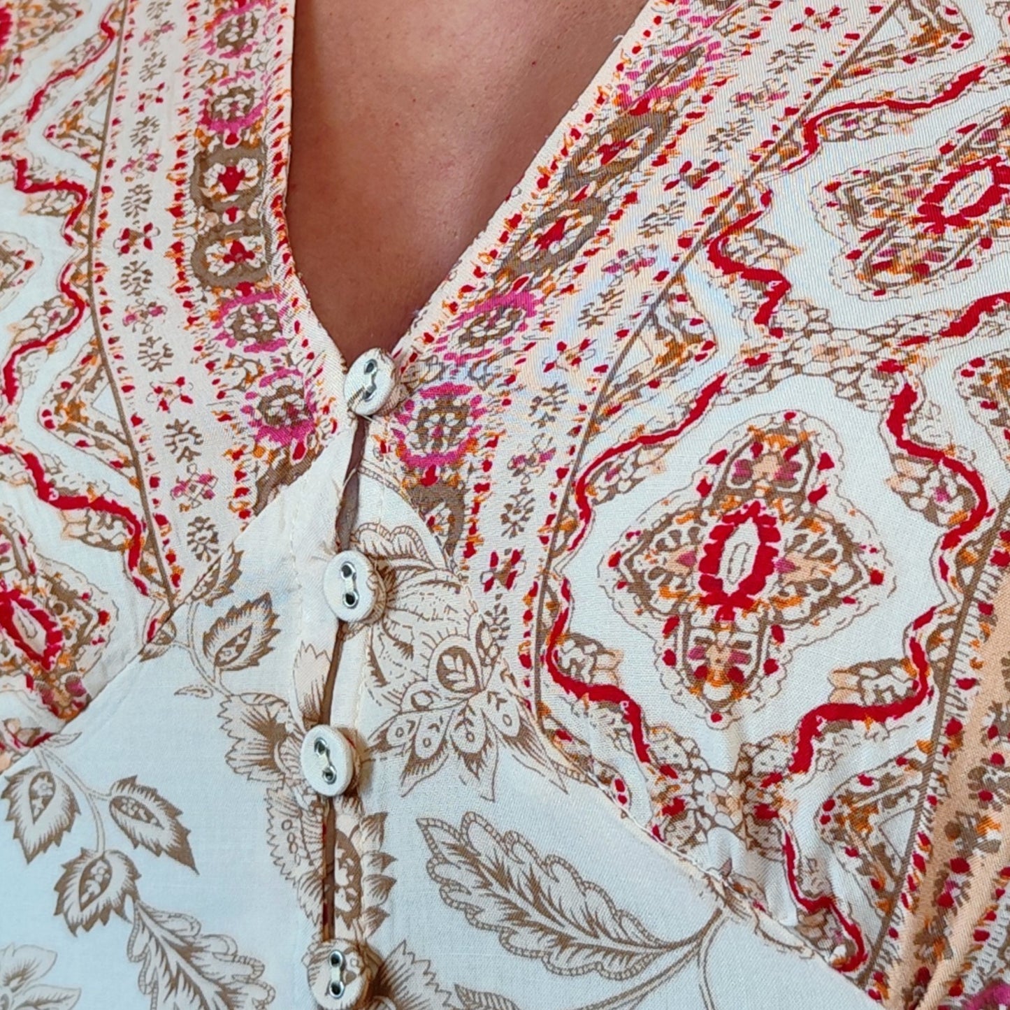 Detalle del pecho del vestido Ítaca con cenefa estampada y botones forrados de tela