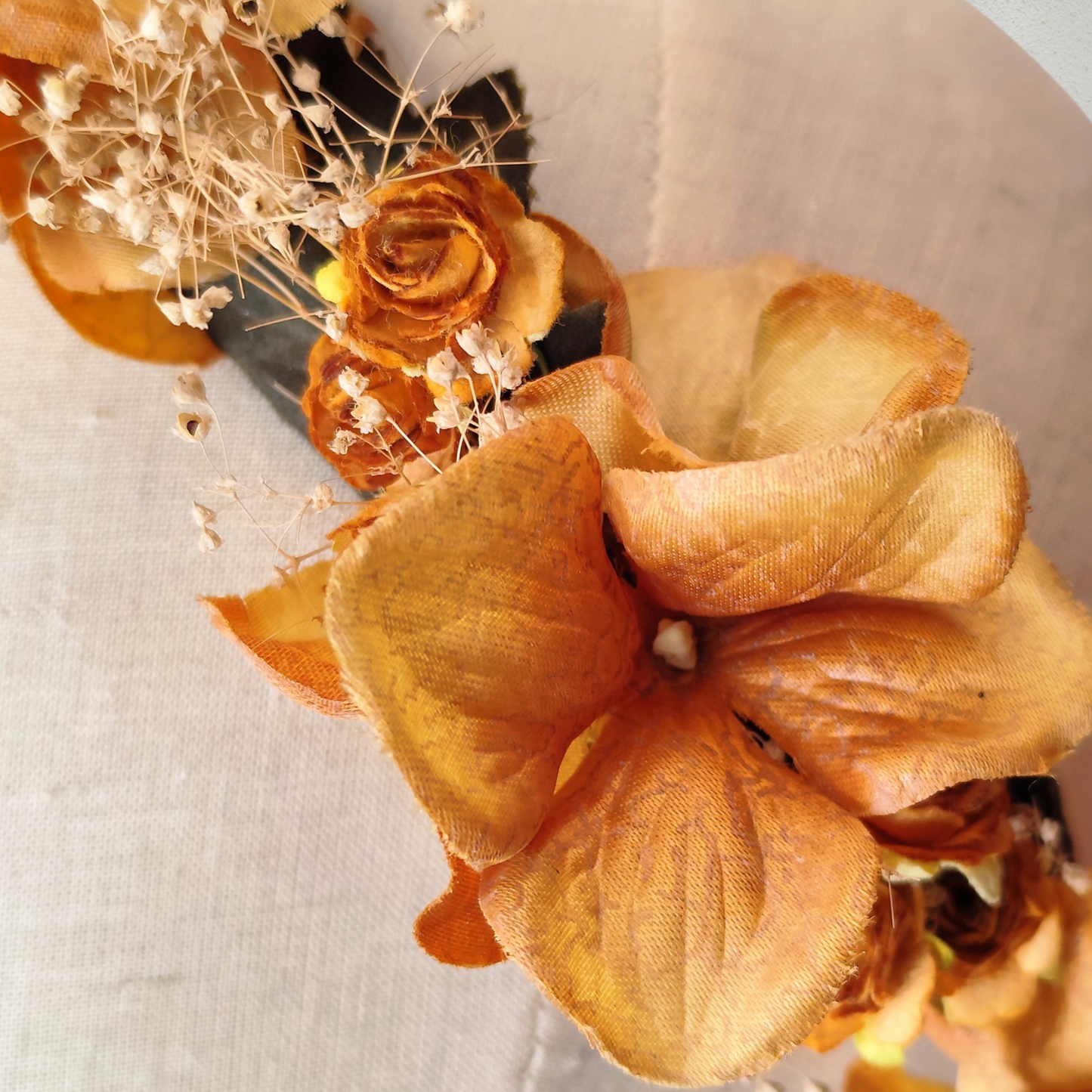 Corona floral artesanal en tonos ocre y mostaza para novia o invitada.