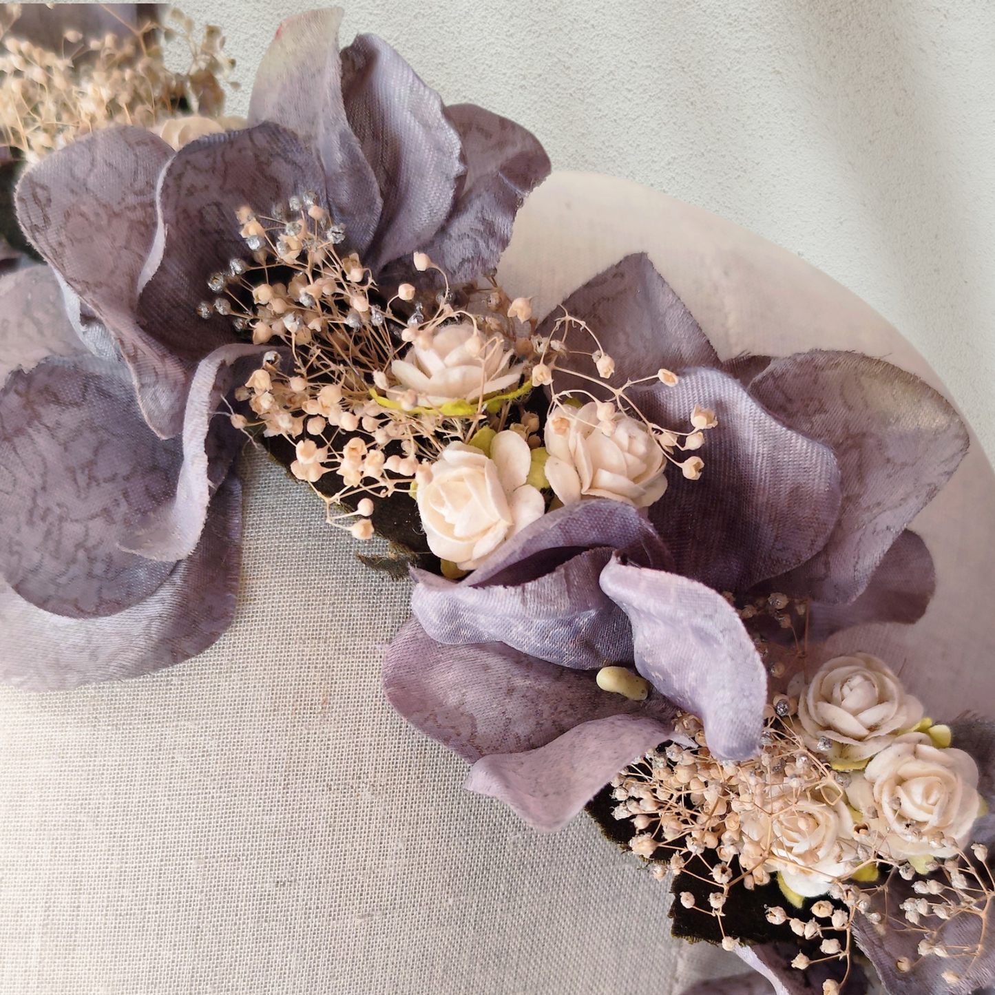 Corona floral artesanal en color gris plateado para novia o invitada, con flores de estilo natural.