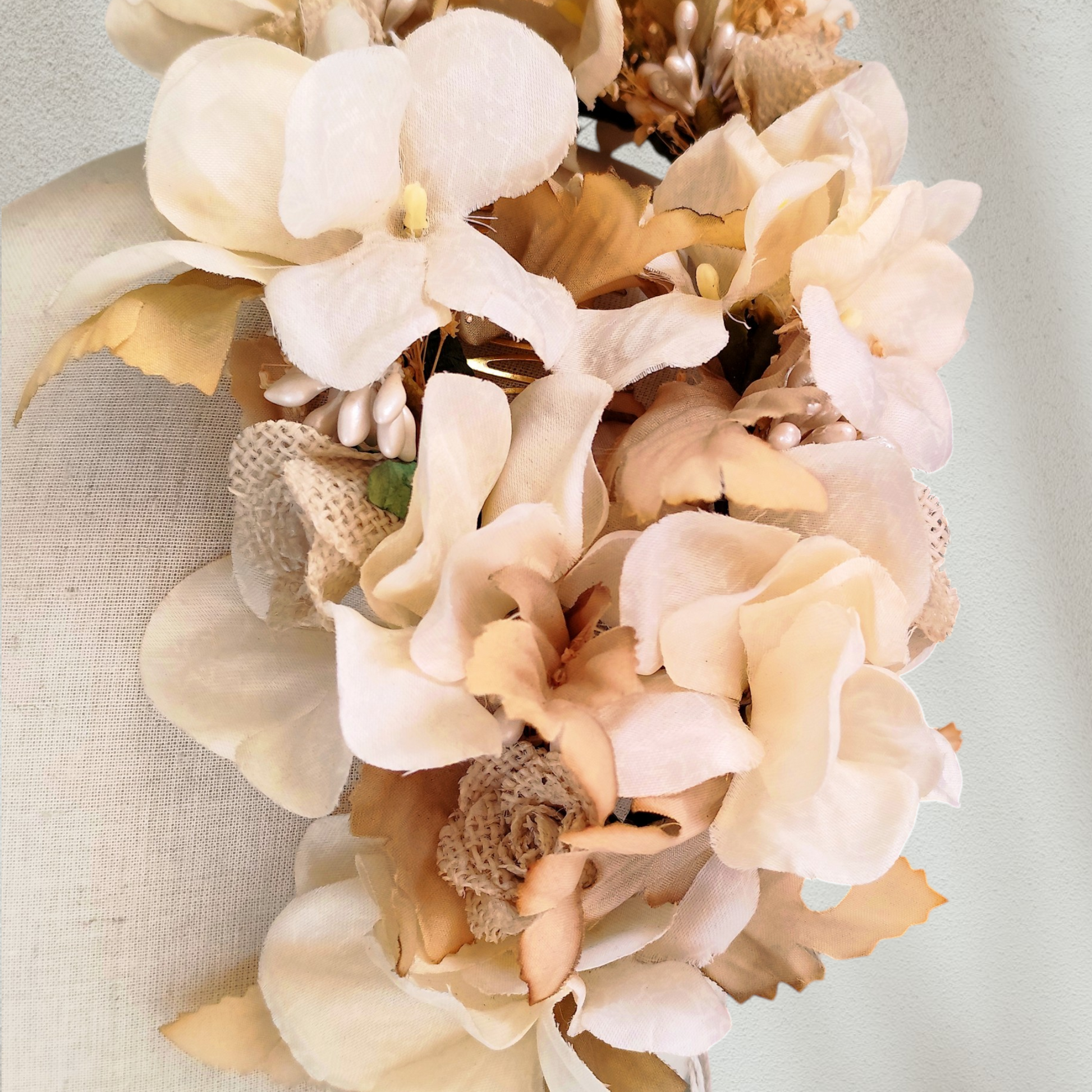 Tocado floral artesanal en tonos blanco roto para novia.