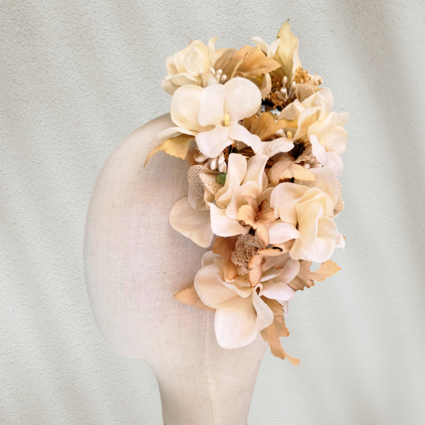 Tocado floral artesanal en tonos blanco roto para novia.