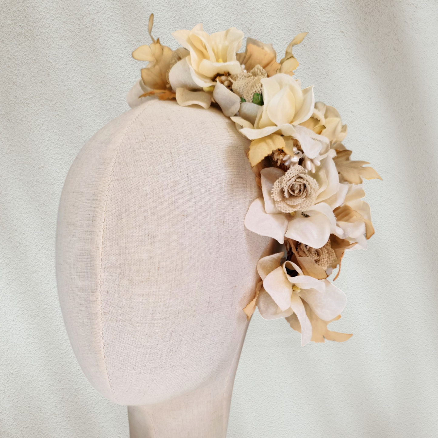 Tocado floral artesanal en tonos blanco roto para novia.
