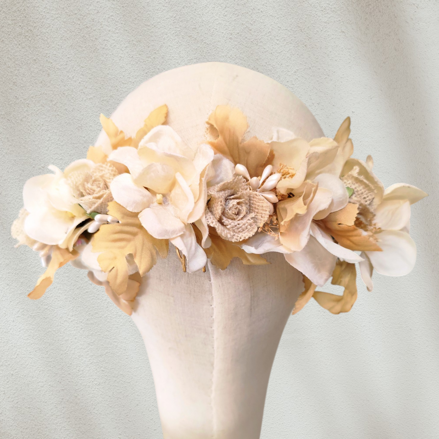 Tocado floral artesanal en tonos blanco roto para novia.