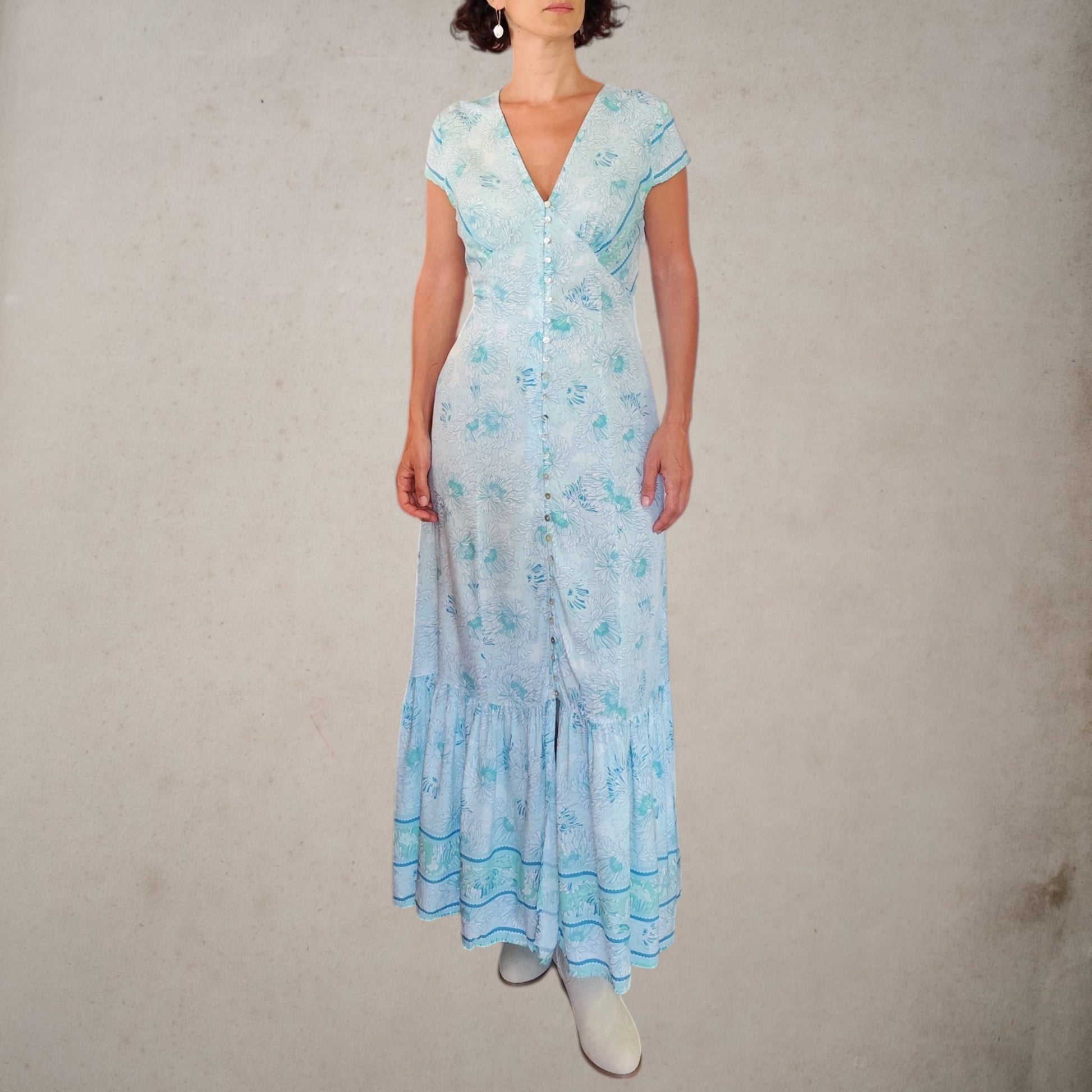 Vestido Acuarela largo estampado en tonos turquesa y verde con botones de nácar, vista frontal completamente cerrado.