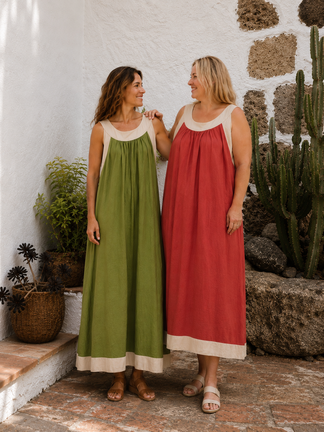 Dos modelos lucen el vestido Callao en verde manzana y terracota en un entorno exterior