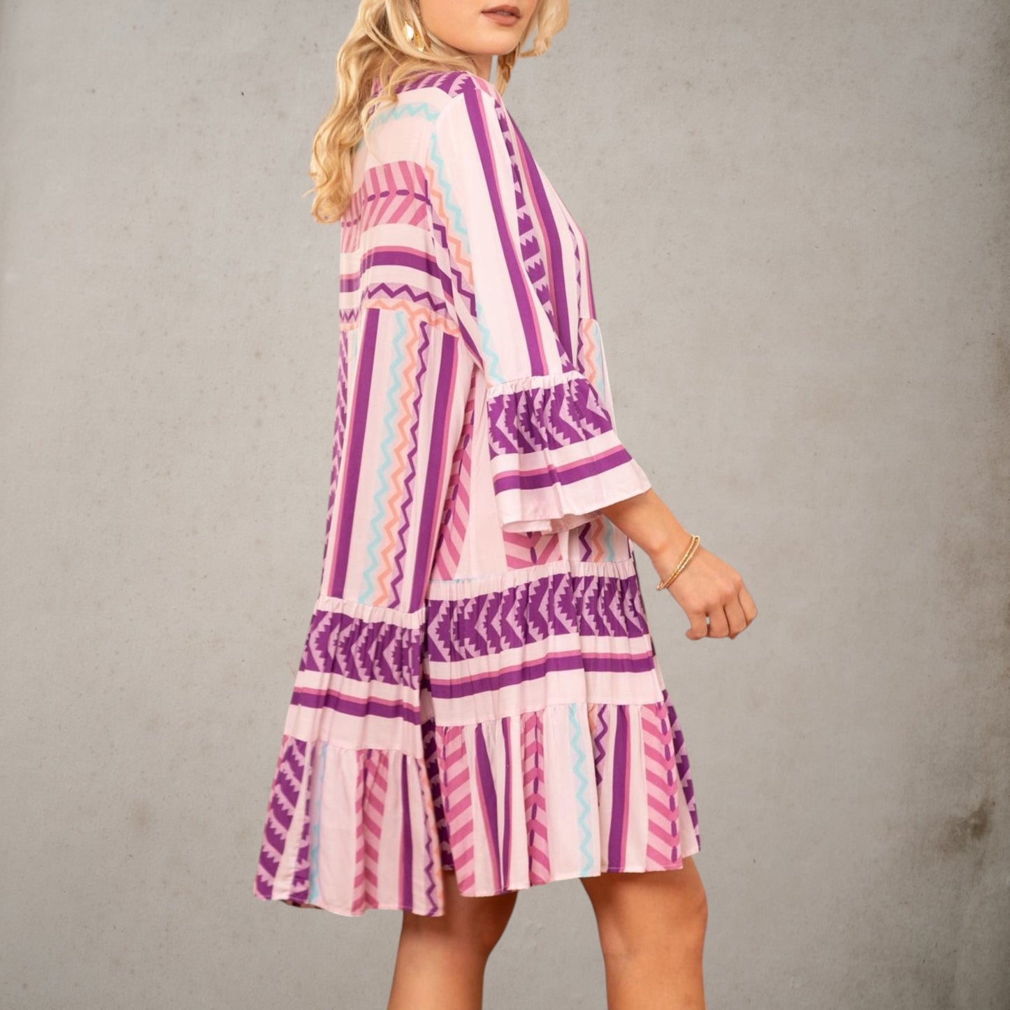 Vista lateral del vestido Dakota de viscosa con manga francesa, falda de volantes y estampado en tonos malva, rosa y azul.
