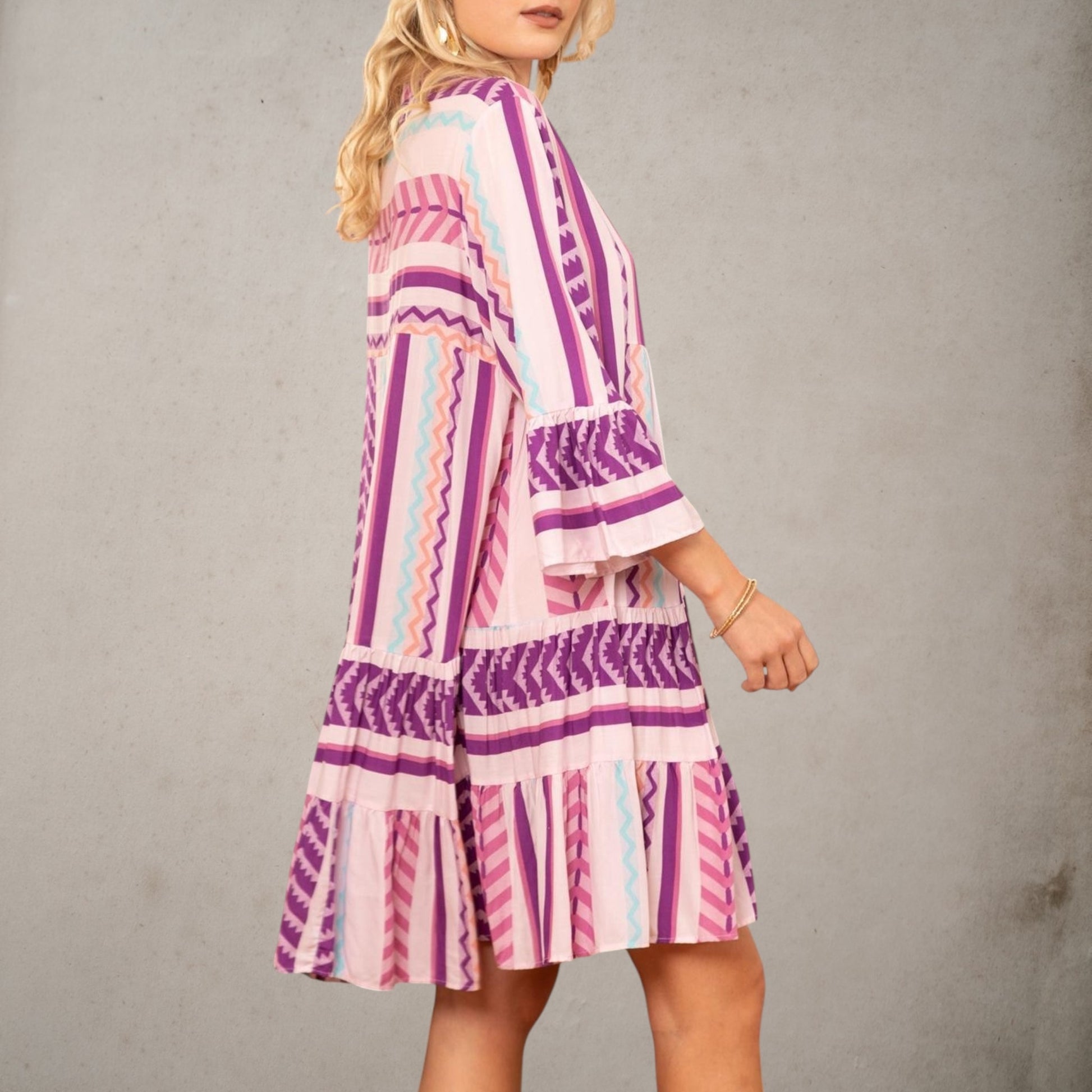 Vista lateral del vestido Dakota de viscosa con manga francesa, falda de volantes y estampado en tonos malva, rosa y azul.