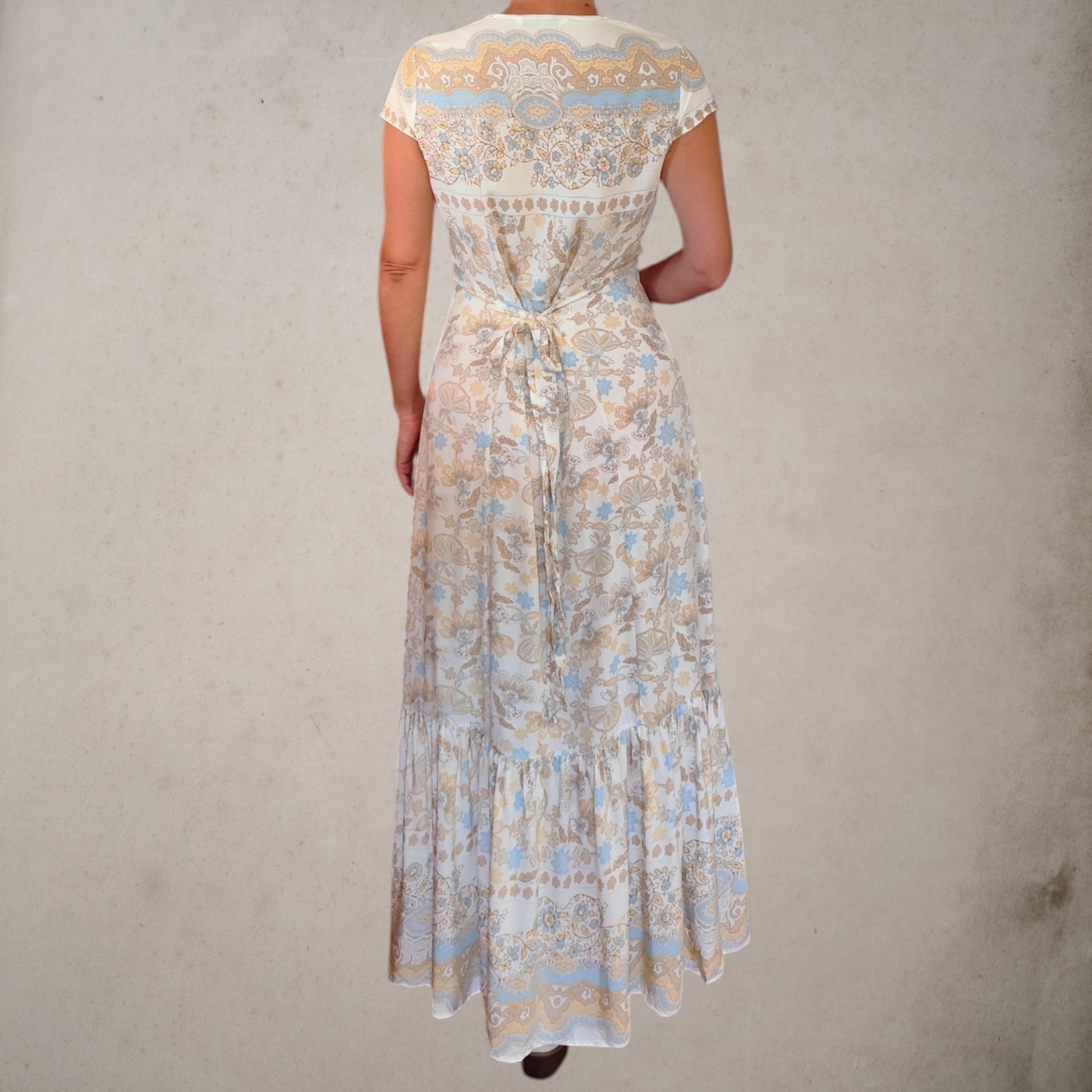 Vista trasera del vestido largo Sáhara con cinturón incorporado para ajustar la silueta y estampado en tonos beige y azul.